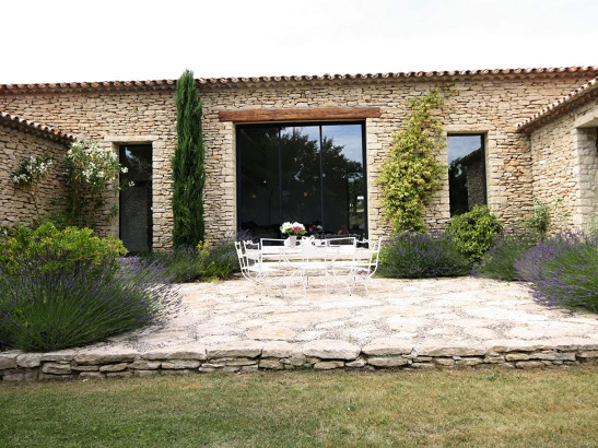 Grande baie vitrée coulissante sur une maison ancienne en pierres