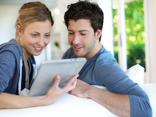 Couple faisant un devis immédiat de fenêtres sur mesure sur leur tablette