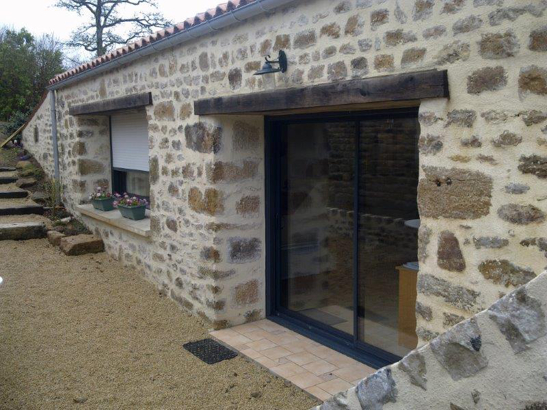 Fenêtre en aluminium gris anthracite sur une maison ancienne en pierres