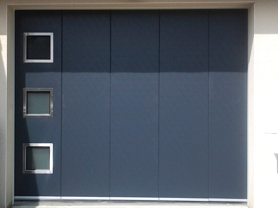 Porte de garage latérale couleur bleu, avec hublots carrés